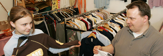 Darstellung von zwei Personen, die vor mehreren Kleiderständern stehen